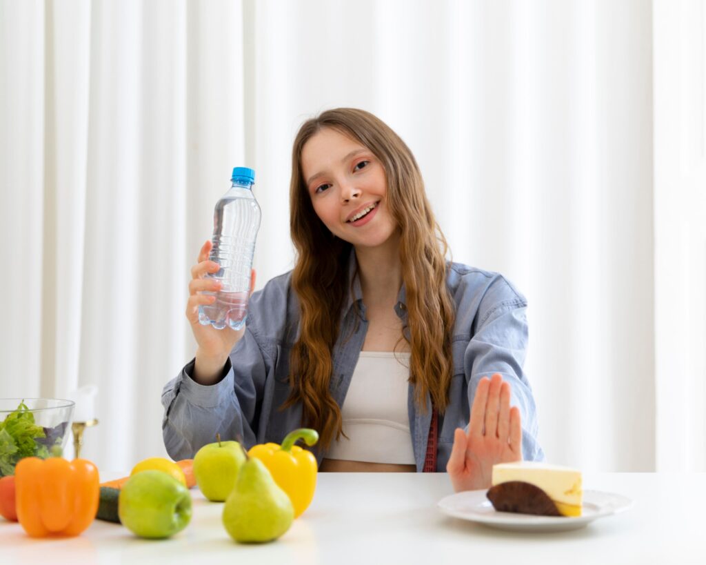 Jeune fille avec une bouteille d'eau et des fruits